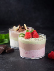 Chia seed pudding with three flavors, cocoa, matcha and strawberry with yoghurt, chocolate and mint leaves. Copy space