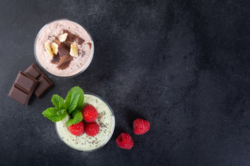 Chia seed pudding with three flavors, cocoa, matcha and strawberry with yoghurt, chocolate and mint leaves. Top view with copy space
