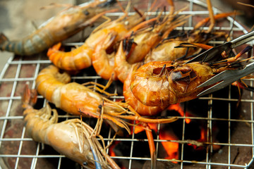 Closeup delicious prawns on charcoal grilled on fire.