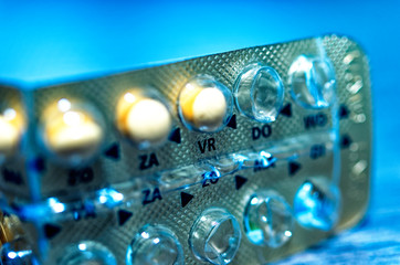 Makroaufnahme einer Antibabypille bei der schon einige Pillen aufgebraucht sind auf Holz