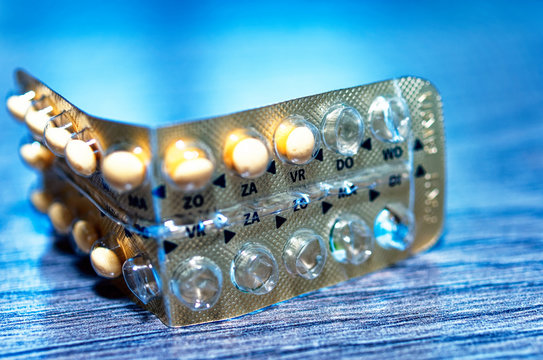 Makroaufnahme einer Antibabypille bei der schon einige Pillen aufgebraucht sind auf Holz