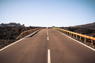 Long way asphalt road in the middle of a scenic landscape made by lava and vulcans - concept of travel in beautiful roads -