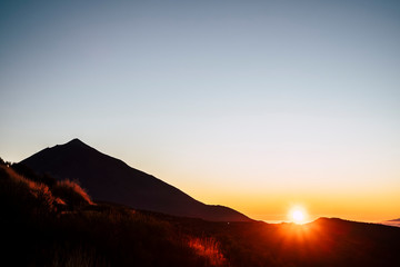 Beatiful scenic sunset time from top of a mountain with sun colors and clear coloured sky - timeless landscape with beauty of nature outdoors