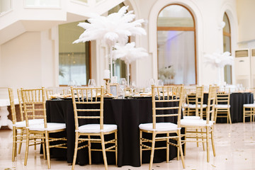 Black tablecloths on big, round tables for a wedding lunch.