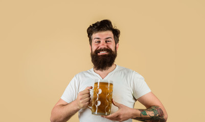 Bearded male tasting fresh brewed beer. Oktoberfest festival. Bearded man drinking beer from glass at bar or pub. Beer in Germany. Craft beer at restaurant. Drink, alcohol, leisure and people concept.