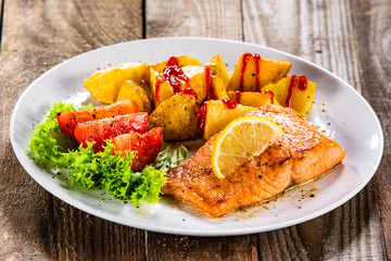 Fried salmon with baked potatoes and vegetables