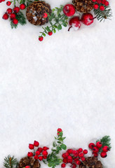 Christmas decoration. Frame of twigs christmas tree, brown natural pine cones and red berries on snow with space for text. Top view, flat lay