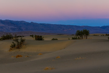 Fototapeta na wymiar Looking Across Sand Dunes of Death Valley at Sun Setting behind Sierra Nevada Mountains