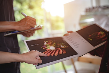 People are reading the menu and ordering food in the morning restaurant.