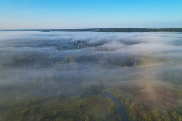 Aerial photography from the drone. Village in the woods in the morning fog