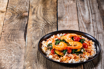 Shrimps with white rice and vegetables on wooden table