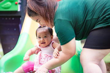 Mom and daughter playing slider at the playground