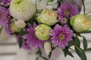 Composition of fresh flowers (chrysateme, rose, matiola. Colors light green, lilac) in a gift box in the form of an envelope