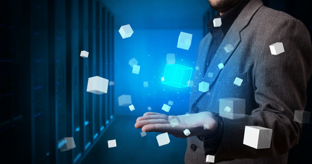 Person holding hologram projection displaying white cubes in server room