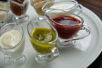 sauces in bowls on a dark wooden background. menu for catering