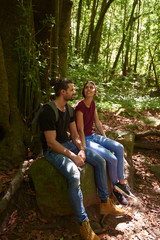 Young couple sitting on a large rock