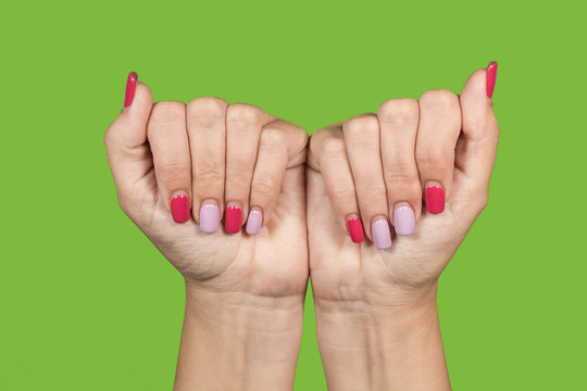 Closeup Top View Of Two Beautiful Hands Of White Woman Isolated On Green Background. Woman Showing Her Trendy Long Lasting Manicure Made With Modern Gel Pollish Or Shellac After 3 Weeks Of Wearing. 