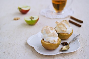 Autumn dessert, baked apples with meringue on a light concrete background. Thanksgiving Day. Harvest apples. Selective focus.