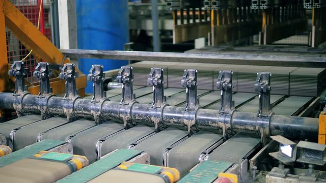 Factory machine cuts cement into bricks.