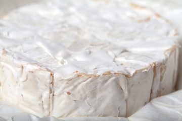 Camembert cheese is cut into pieces and whole.