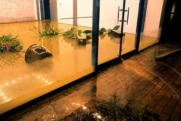  Water flowing through doors from a flooded office. Effects Tropical depression Imelda. Houston,...