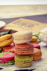 Sweet and colorful macarons. Closeup macaroons on a plate. Tasty french delicate dessert for breakfast. Vintage tone style.