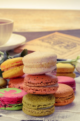 Sweet and colorful macarons. Closeup macaroons on a plate. Tasty french delicate dessert for breakfast. Vintage tone style.