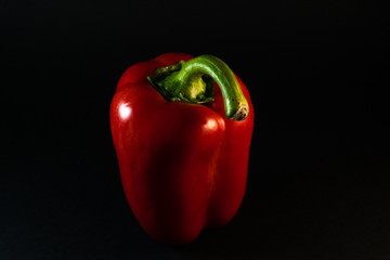 Fresh and tasty, isolated red bell paprika on the black background