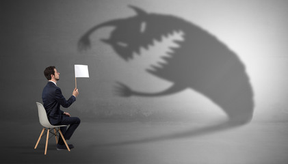 Young businessman staying and negotiate with a monster shadow