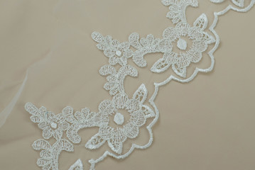 Texture lace fabric. lace on white background studio. thin fabric made of yarn or thread. a background image of ivory-colored lace cloth. White lace on beige background.