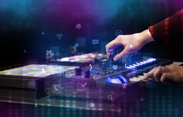 Naklejka na ściany i meble Hand mixing music on dj controller with social media concept icons