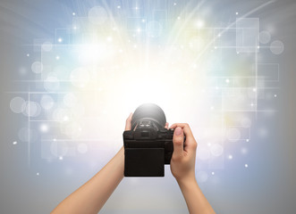 Naked hand taking picture with digital camera and glowing flash concept