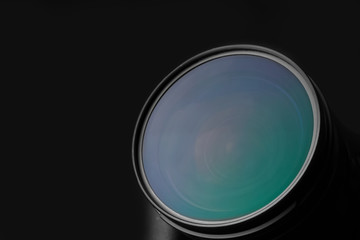 Modern camera on dark background, closeup of lens. Space for text