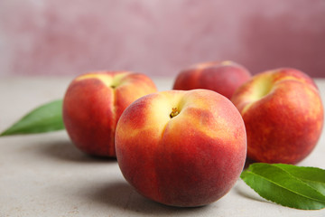 Fresh juicy peaches and leaves on light table