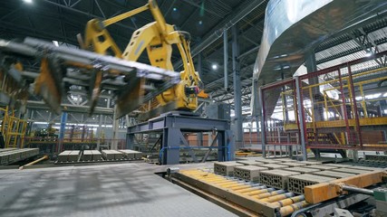 Automated machine moves bricks on a working conveyor.