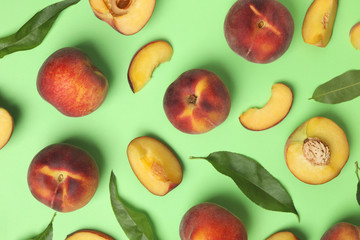 Flat lay composition with sweet juicy peaches on green background