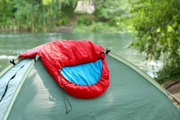 Sleeping bag on camping tent near lake