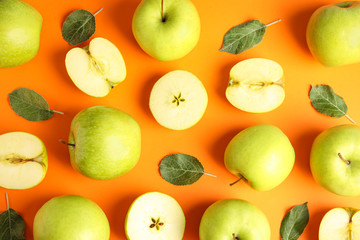 Flat lay composition of fresh ripe green apples on orange background