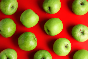 Flat lay composition of fresh ripe green apples on red background