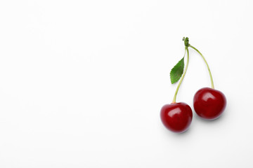 Delicious ripe sweet cherries with leaf on white background