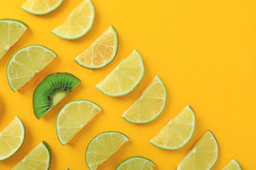 Flat lay composition with slices of  juicy exotic fruits on yellow background. Space for text