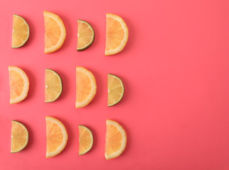 Flat lay composition with slices of  juicy exotic fruits on pink background. Space for text