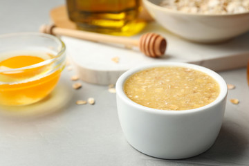 Handmade face mask and different ingredients on grey stone background, closeup