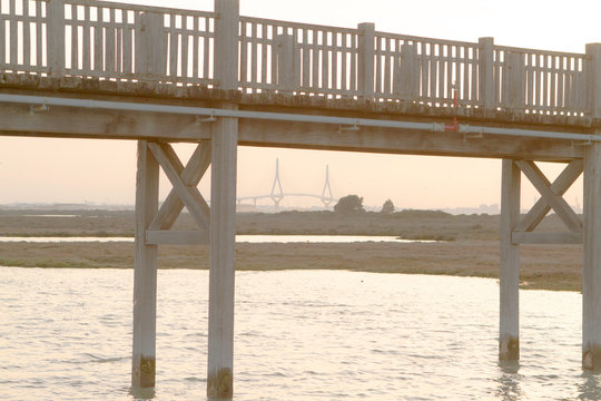 Wooden walkway brigde over sea and marsh. Background Suspension Brigde