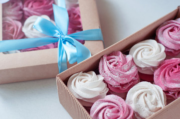 white and pink marshmallows, marshmallows in a gift box. sweet gift. blue gift ribbon.