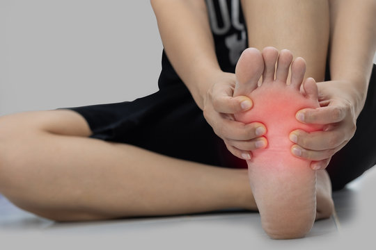 Woman sitting on the floor Her hand caught at the foot pain