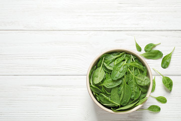 Fresh green healthy spinach on white wooden table, flat lay. Space for text