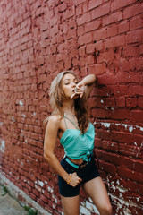 sexy Women near the brick wall sucks her finger