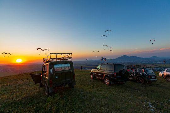 Adventure. Russia. Offroad cars and paragliders on the top of the mountain in Caucasus