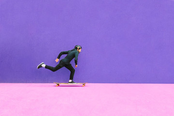 Full length of man skateboarding against wall